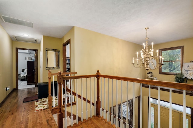 3449 S Woodstock Dr, Springfield, MO 65809 - hallway with an upstairs landing, wood finished floors, and a chandelier