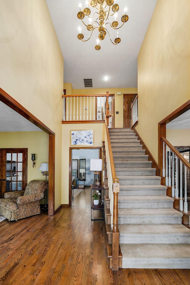 3449 S Woodstock Dr, Springfield, MO 65809 - staircase with a chandelier, wood finished floors, and a towering ceiling