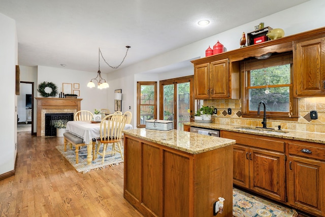 3449 S Woodstock Dr, Springfield, MO 65809 - kitchen with a kitchen island, light wood-style floors, light stone counters, and backsplash