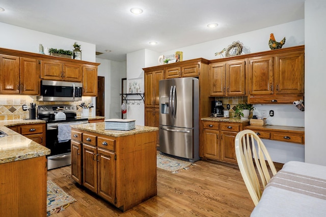 3449 S Woodstock Dr, Springfield, MO 65809 - kitchen featuring appliances with stainless steel finishes, decorative backsplash, brown cabinets, light wood-style floors, and recessed lighting