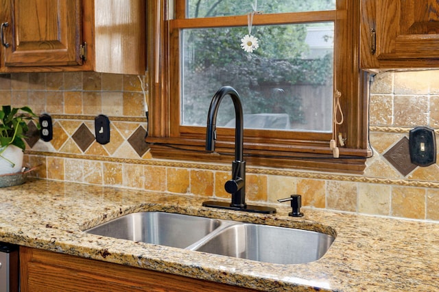 3449 S Woodstock Dr, Springfield, MO 65809 - kitchen view of backsplash, brown cabinetry, and light stone countertops