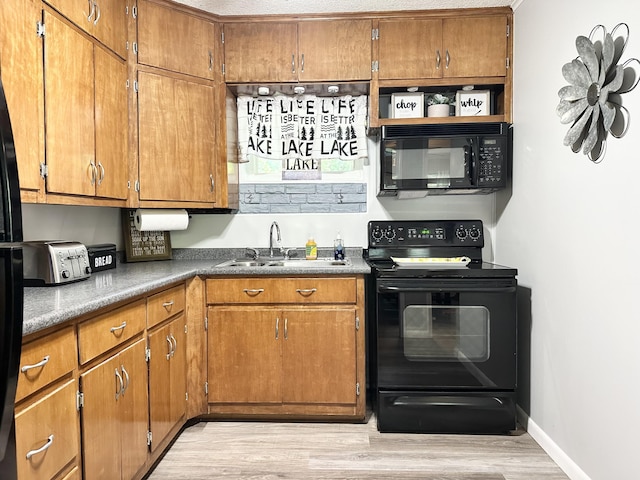 25419 County Road 327, Urbana, MO 65767 - kitchen featuring black appliances, light wood-style floors, and brown cabinetry