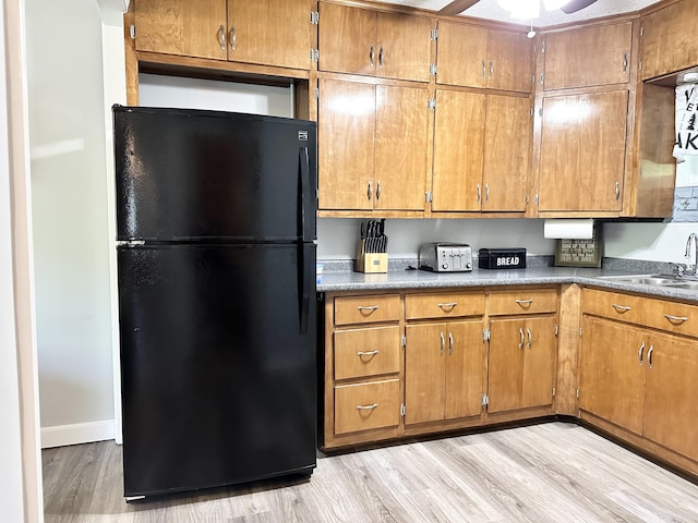 25419 County Road 327, Urbana, MO 65767 - kitchen with freestanding refrigerator, brown cabinets, light wood-style flooring, and a ceiling fan