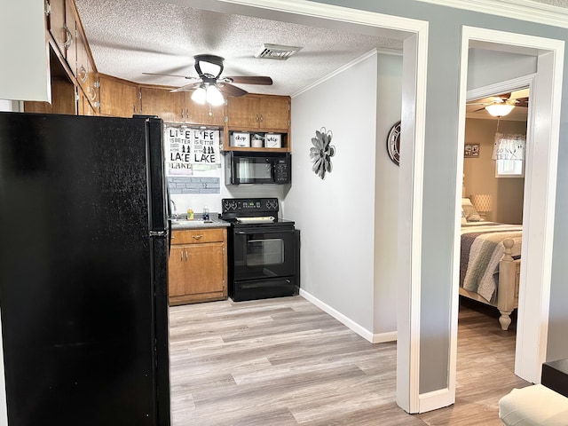 25419 County Road 327, Urbana, MO 65767 - kitchen with black appliances, ceiling fan, brown cabinetry, light wood-style flooring, and ornamental molding
