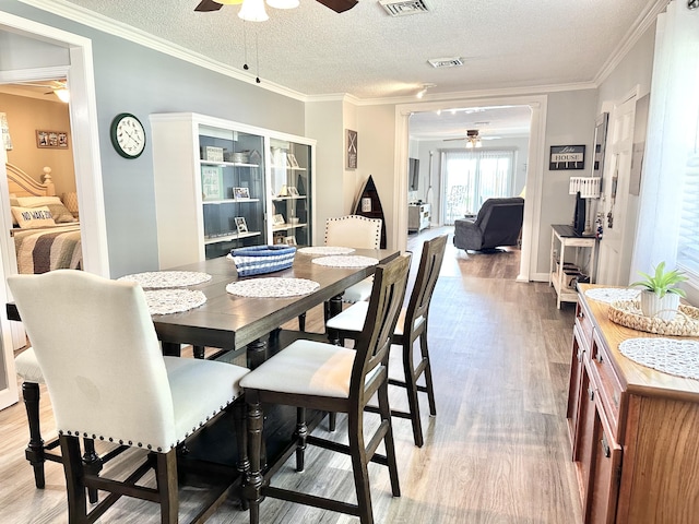25419 County Road 327, Urbana, MO 65767 - dining area featuring a ceiling fan, light wood-style flooring, a textured ceiling, and ornamental molding