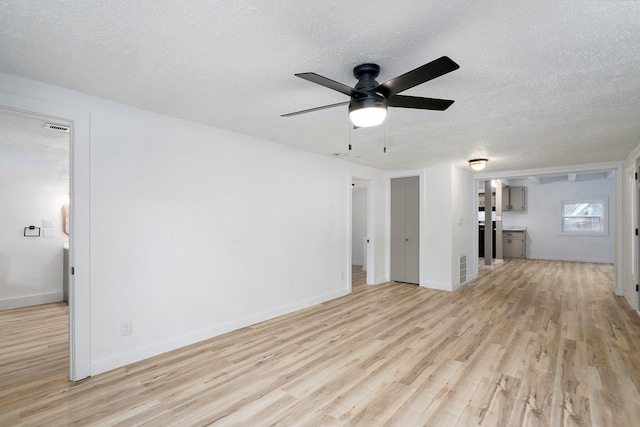 1169 S Miller Ave, Springfield, MO 65802 - unfurnished living room featuring ceiling fan, light wood-style flooring, and a textured ceiling