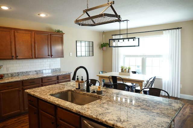 1129 S Erika Ave, Springfield, MO 65802 - kitchen with dark wood-type flooring, tasteful backsplash, recessed lighting, a center island with sink, and light stone countertops