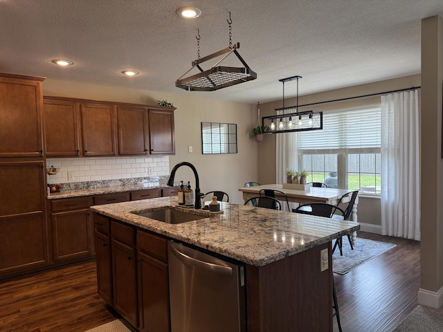 1129 S Erika Ave, Springfield, MO 65802 - kitchen featuring stainless steel dishwasher, a kitchen breakfast bar, dark wood-style flooring, a center island with sink, and decorative backsplash