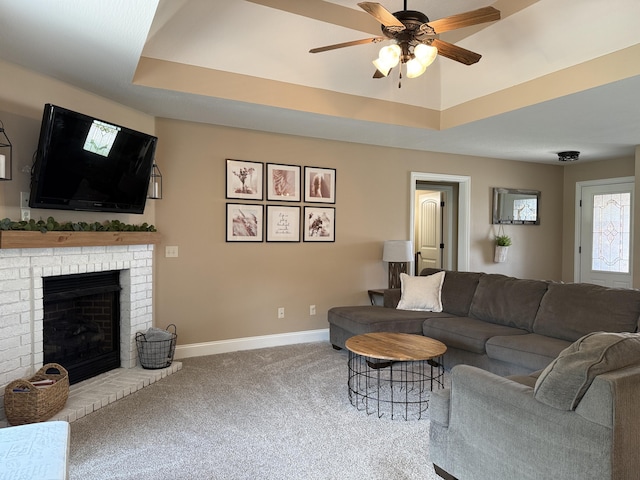 1129 S Erika Ave, Springfield, MO 65802 - living room with ceiling fan, carpet floors, a raised ceiling, and a brick fireplace