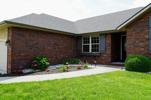 1129 S Erika Ave, Springfield, MO 65802 - view of property exterior featuring brick siding, roof with shingles, a garage, and a yard