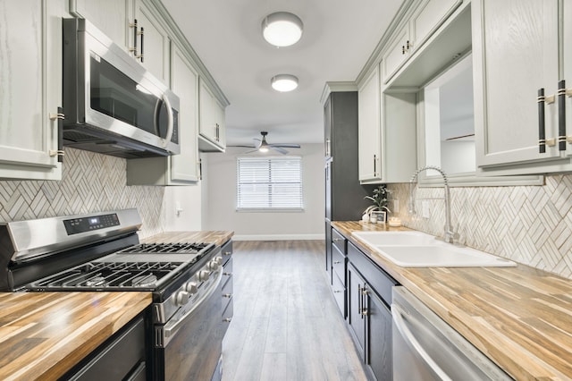 210 N Cedarbrook Ave, Springfield, MO 65802 - kitchen featuring stainless steel appliances, wood counters, ceiling fan, backsplash, and light wood-type flooring