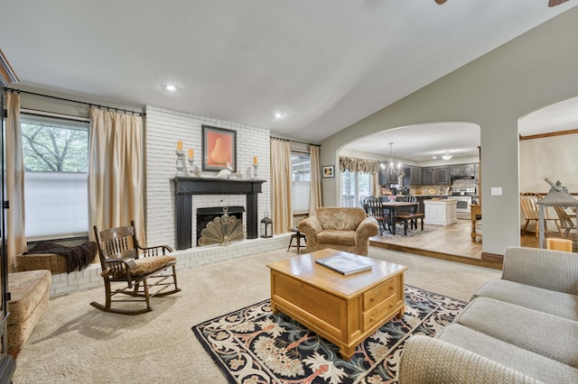 1820 E Jacqueline St, Springfield, MO 65804 - living room featuring arched walkways, healthy amount of natural light, lofted ceiling, a fireplace, and light carpet