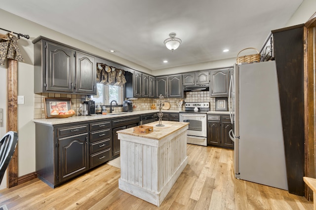 1820 E Jacqueline St, Springfield, MO 65804 - kitchen with appliances with stainless steel finishes, under cabinet range hood, wooden counters, tasteful backsplash, and a center island