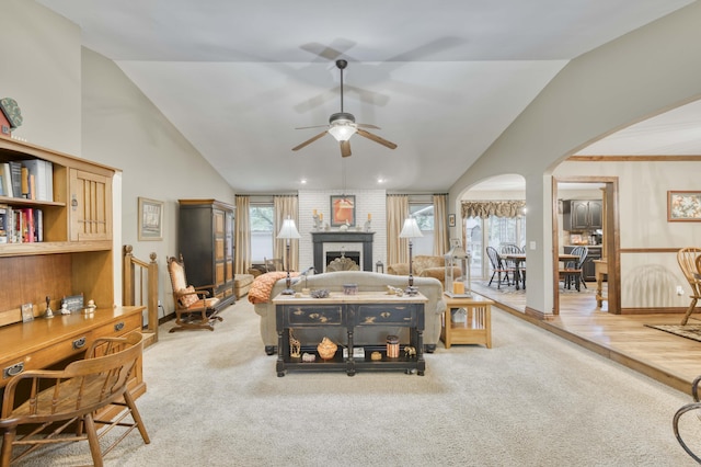 1820 E Jacqueline St, Springfield, MO 65804 - carpeted living area with arched walkways, vaulted ceiling, a ceiling fan, and a brick fireplace