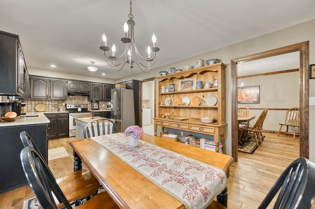 1820 E Jacqueline St, Springfield, MO 65804 - dining space featuring a chandelier, washer / clothes dryer, and light wood-style floors