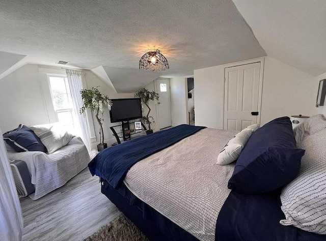 135 Coulter Ln, Forsyth, MO 65653 - bedroom featuring vaulted ceiling, a textured ceiling, and wood finished floors