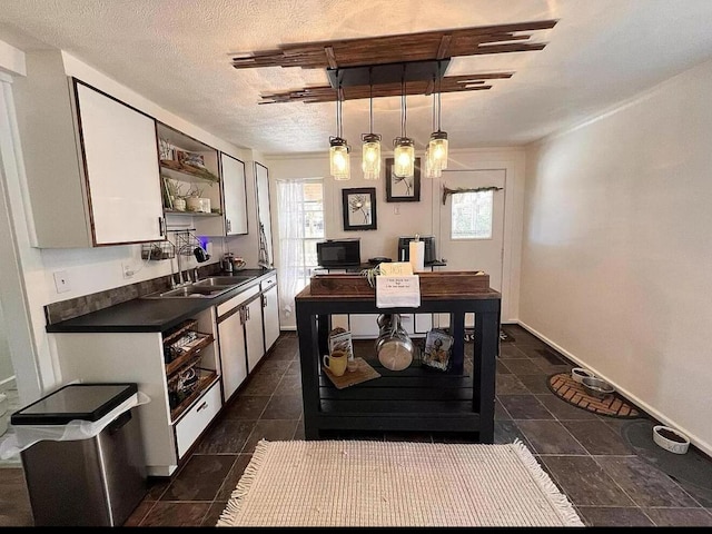 135 Coulter Ln, Forsyth, MO 65653 - kitchen featuring dark countertops, open shelves, white cabinets, hanging light fixtures, and a textured ceiling