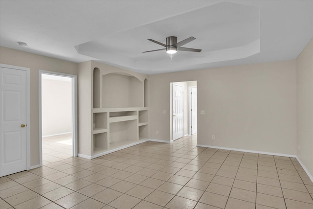 2431 N Kellett Ave, Springfield, MO 65803 - empty room with a tray ceiling, built in shelves, light tile patterned flooring, and a ceiling fan