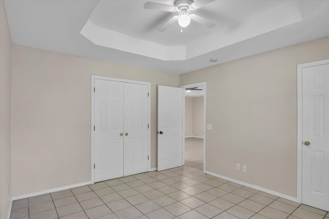 2431 N Kellett Ave, Springfield, MO 65803 - unfurnished bedroom with a raised ceiling, light tile patterned flooring, a closet, and ceiling fan