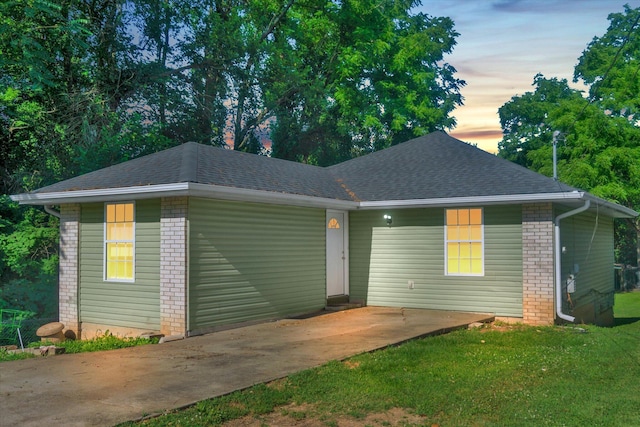 2431 N Kellett Ave, Springfield, MO 65803 - view of front of home featuring brick siding, a front lawn, and a shingled roof