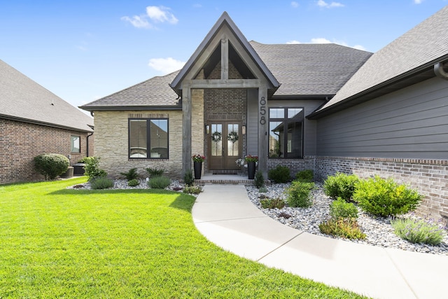 858 E Edenmore Cir, Nixa, MO 65714 - property entrance with french doors, a lawn, brick siding, a shingled roof, and stone siding