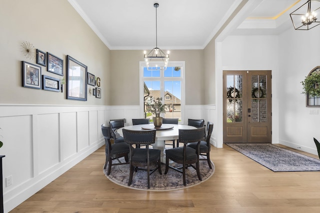 858 E Edenmore Cir, Nixa, MO 65714 - dining space with a chandelier, crown molding, wainscoting, a decorative wall, and wood finished floors