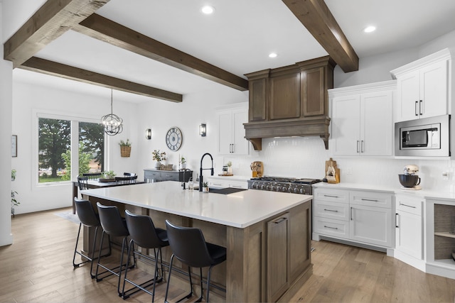 858 E Edenmore Cir, Nixa, MO 65714 - kitchen with stainless steel appliances, beamed ceiling, decorative backsplash, light countertops, and light wood-style floors