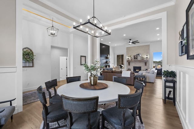 858 E Edenmore Cir, Nixa, MO 65714 - dining room with a large fireplace, ceiling fan, wood finished floors, crown molding, and recessed lighting