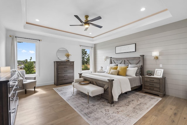 858 E Edenmore Cir, Nixa, MO 65714 - bedroom featuring a tray ceiling, light wood-type flooring, recessed lighting, a ceiling fan, and wood walls