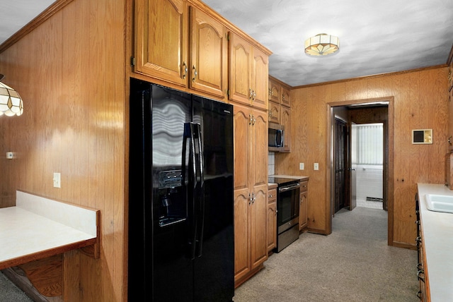 3066 E Lomita St, Springfield, MO 65804 - kitchen with stainless steel appliances, light colored carpet, wooden walls, brown cabinetry, and light countertops