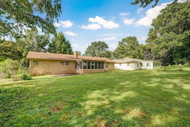 3066 E Lomita St, Springfield, MO 65804 - back of house featuring a chimney, brick siding, and a yard