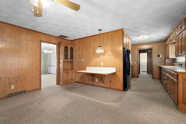 3066 E Lomita St, Springfield, MO 65804 - kitchen with brown cabinets, black refrigerator with ice dispenser, light carpet, wood walls, and light countertops