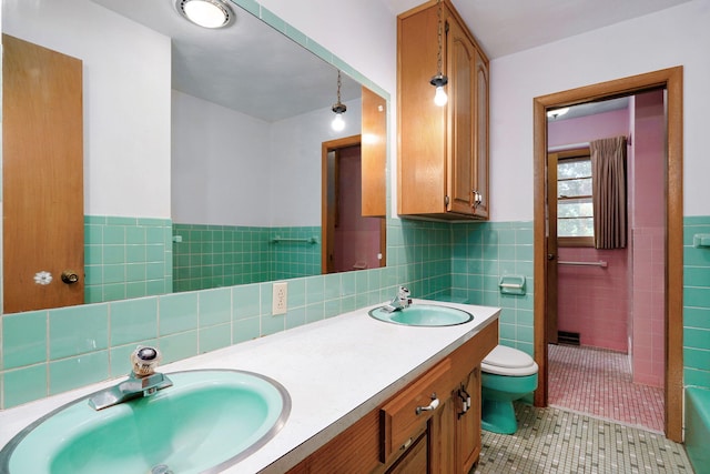 3066 E Lomita St, Springfield, MO 65804 - full bath featuring tile patterned floors, double vanity, tile walls, wainscoting, and a bathtub