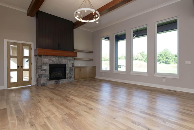 6059 S Clay Ave, Springfield, MO 65810 - unfurnished living room with beamed ceiling, a chandelier, light wood-style floors, healthy amount of natural light, and a stone fireplace
