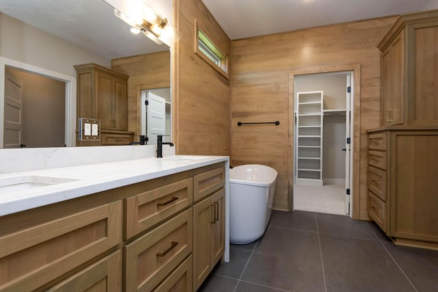 6059 S Clay Ave, Springfield, MO 65810 - full bathroom featuring double vanity, a freestanding bath, tile patterned floors, a walk in closet, and wooden walls