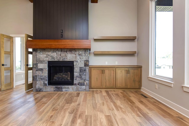 6059 S Clay Ave, Springfield, MO 65810 - unfurnished living room with light wood-style floors and a stone fireplace
