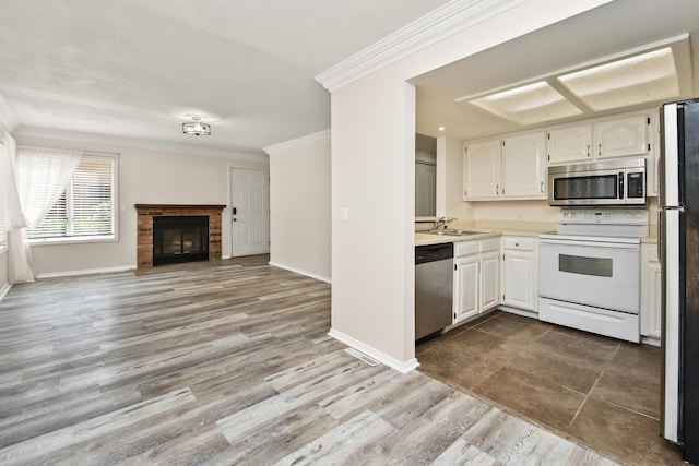 3440 S Delaware Ave Unit 114, Springfield, MO 65804 - kitchen with stainless steel appliances, crown molding, open floor plan, light countertops, and white cabinets