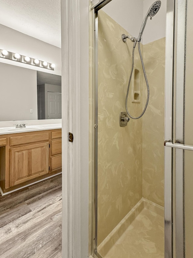 3440 S Delaware Ave Unit 114, Springfield, MO 65804 - bathroom featuring a stall shower, vanity, and wood finished floors