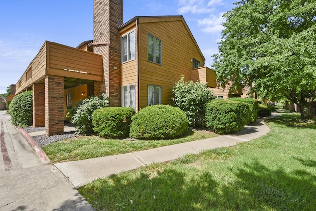 3440 S Delaware Ave Unit 114, Springfield, MO 65804 - view of side of home featuring a chimney, a yard, and a balcony