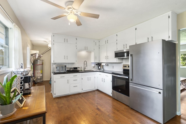 2558 S Nettleton Ave, Springfield, MO 65807 - kitchen with appliances with stainless steel finishes, water heater, ceiling fan, dark countertops, and backsplash