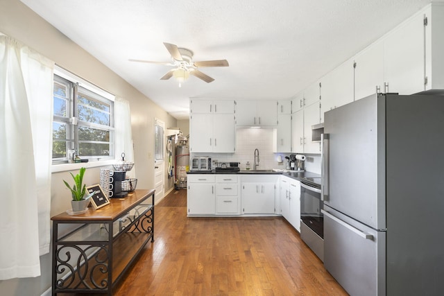 2558 S Nettleton Ave, Springfield, MO 65807 - kitchen with stainless steel appliances, a ceiling fan, dark countertops, hardwood / wood-style flooring, and decorative backsplash