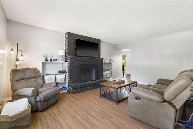 2558 S Nettleton Ave, Springfield, MO 65807 - living area with wood finished floors, a brick fireplace, and a textured ceiling