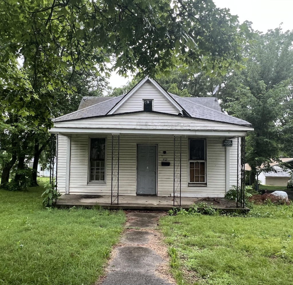 402 2nd St, Monett, MO 65708 - view of front of house with a porch, roof with shingles, and a front yard