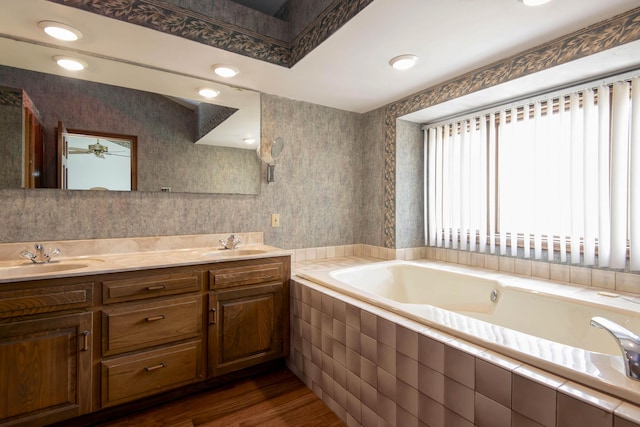 3501 E Cooper Blvd, Springfield, MO 65802 - bathroom featuring a bath, double vanity, wood finished floors, wallpapered walls, and ceiling fan