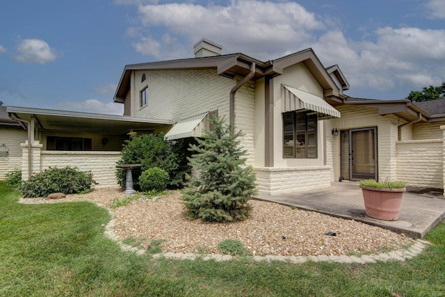 3501 E Cooper Blvd, Springfield, MO 65802 - view of property exterior featuring a chimney, brick siding, and a yard