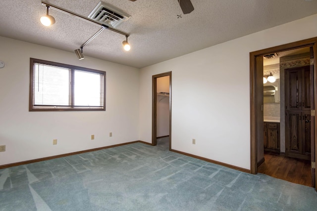 3501 E Cooper Blvd, Springfield, MO 65802 - unfurnished bedroom with carpet, a walk in closet, ensuite bath, a textured ceiling, and a ceiling fan