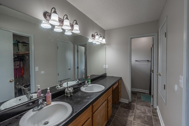 2981 W Highpoint St, Springfield, MO 65810 - bathroom with double vanity, a textured ceiling, tile patterned floors, a chandelier, and a spacious closet