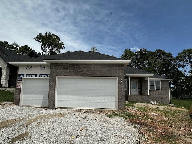 5569 E Wild Horse Dr, Springfield, MO 65802 - ranch-style home with an attached garage, brick siding, and gravel driveway