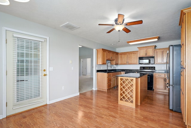 287 N Metzletein Rd, Billings, MO 65610 - kitchen with black appliances, ceiling fan, a kitchen island, light wood-style floors, and a textured ceiling