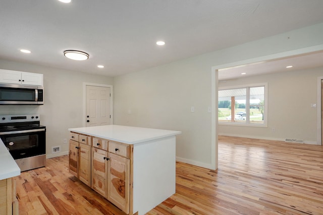7208 N Farm Rd Unit 133, Springfield, MO 65803 - kitchen featuring stainless steel appliances, light wood-type flooring, recessed lighting, light countertops, and a center island